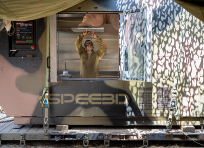 SPEE3D deployable expeditionary technology-Bradshaw_6579_AMC technician setting up print_susbtrate installation 1