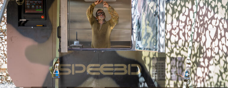 SPEE3D deployable expeditionary technology-Bradshaw_6579_AMC technician setting up print_susbtrate installation 1